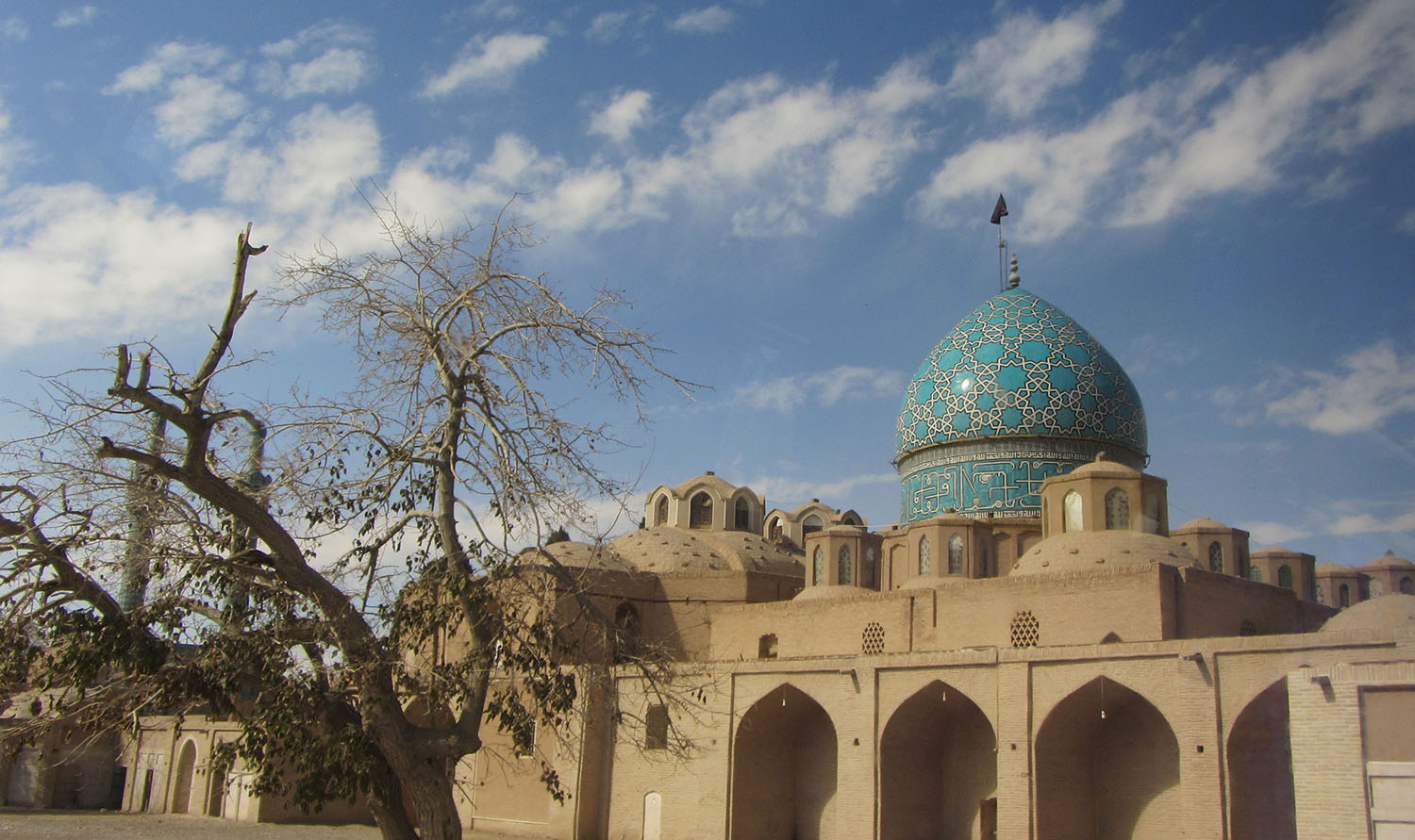 تضاد رنگ فیروزه ای بناهای مهم شهر کرمان با زمینه خاکی شهر